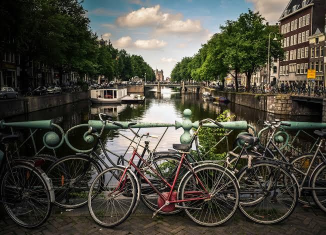 Fietsen tegen een brugleuning aan een Amsterdamse gracht